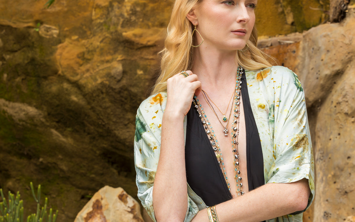 Beautiful blonde wearing yellow gold green diamond, white diamond, keshi pearl, and other Dominique Cohen jewelry with pressed-flower silk kimono over bathing suit; 323-404-2959 for shop help
